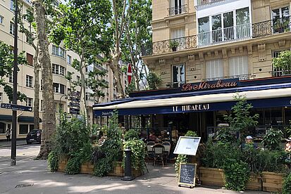Ein Eckrestaurant in Paris mit Marquise und Tischen vor der Tür
