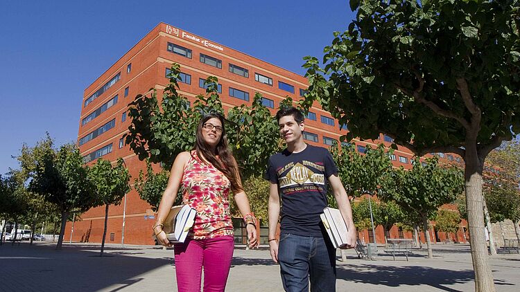 students in front of the building of Facultad de Economiaon campus in Valencia