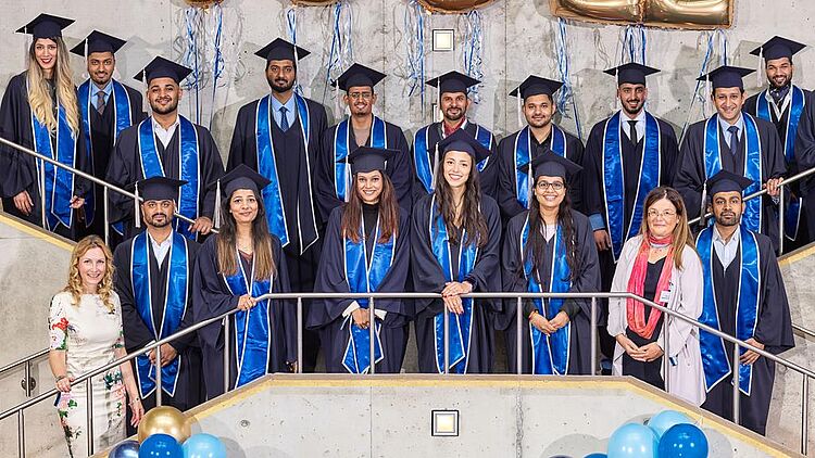 Absolventen des MBA Global Management in Talaren beim Gruppenfoto