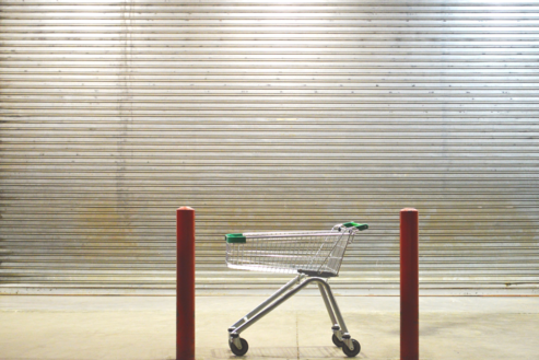 Shopping cart in front of closed supermarket