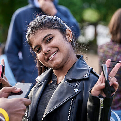 smiling international student showing victory sign