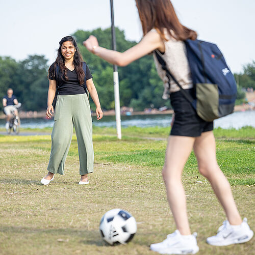 Zwei Studentinnen spielen Fußball