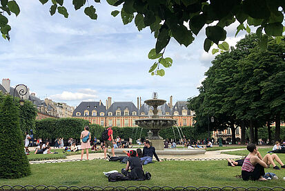 Park-like Place de Vosges with people sitting outside in the green