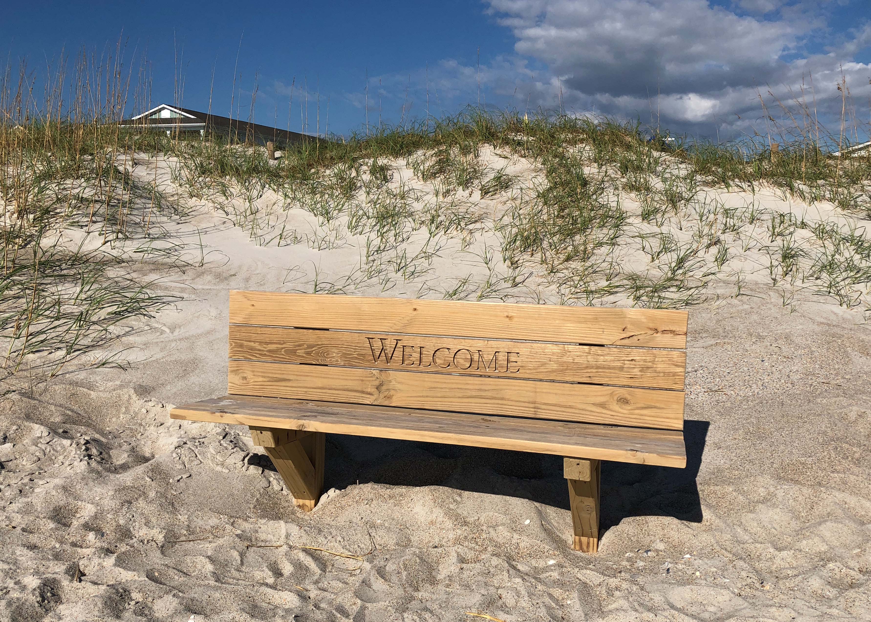 Eine Bank mit Inschrift "Welcome" am Strand von Wrightsville